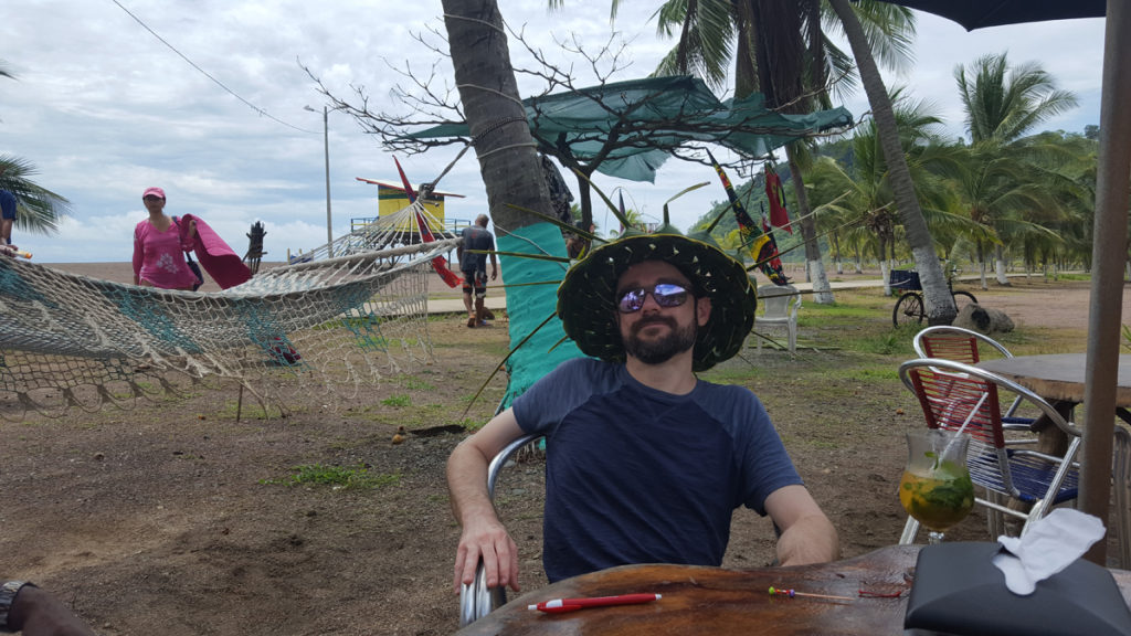 Having a drink on the beach in Jaco & rocking a newly hand-woven palm leaf hat.